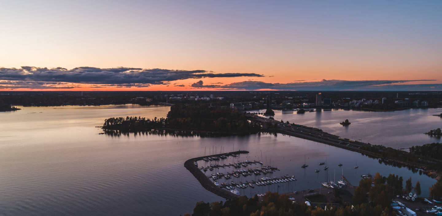 Ilmakuvaa auringonlaskun aikaan mereltä kohti Espoota.