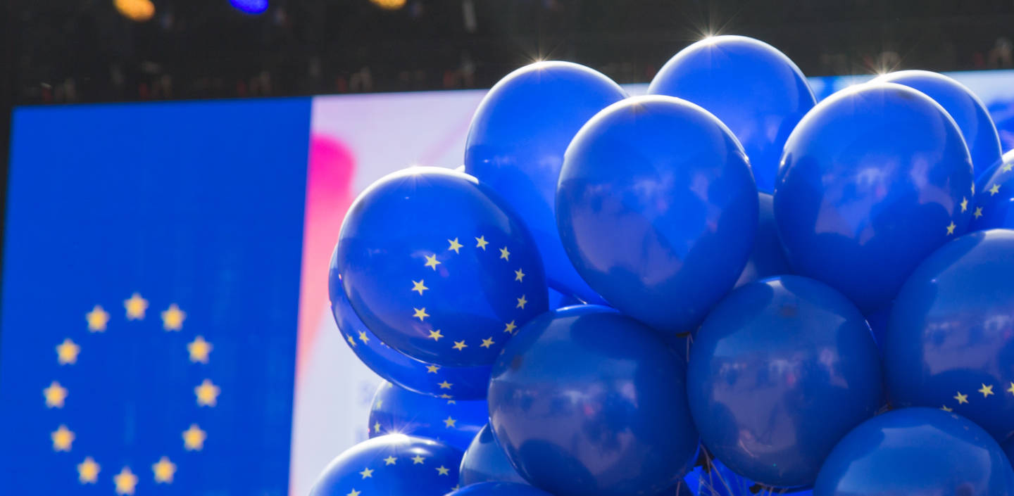 Sinisiä ilmapalloja, joissa EU:n keltaiset tähdet ympyrän muodossa.