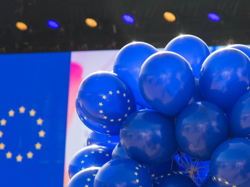 Sinisiä ilmapalloja, joissa EU:n keltaiset tähdet ympyrän muodossa.