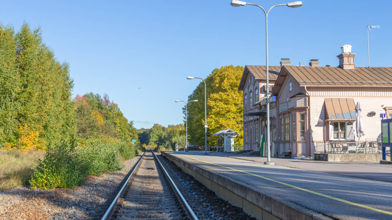 Junaraide sekä oikealla puolella puurakennus, joka on Tammisaaren juna-asema.