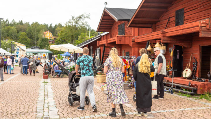 Punaisia puuaittoja ja ihmisiä kävelemässä.