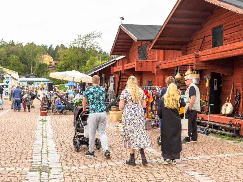 Punaisia puuaittoja ja ihmisiä kävelemässä.