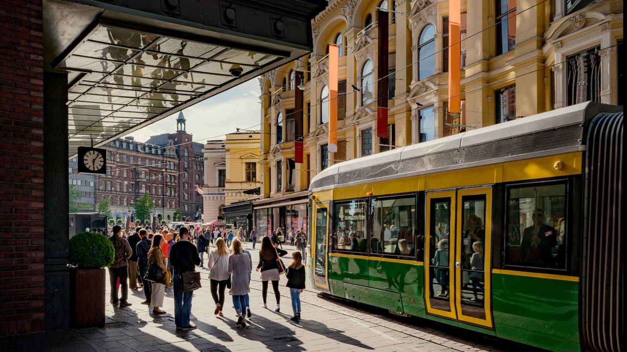 Raitiovaunu ja ihmisiä jalkakäytävällä Aleksanterinkadulla