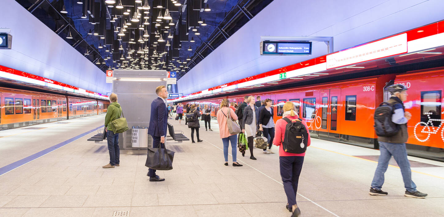 Ihmisiä ja kaksi metroa Espoon Keilaniemen metroasemalla.