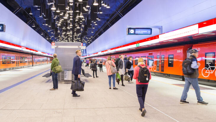 Ihmisiä ja kaksi metroa Espoon Keilaniemen metroasemalla.