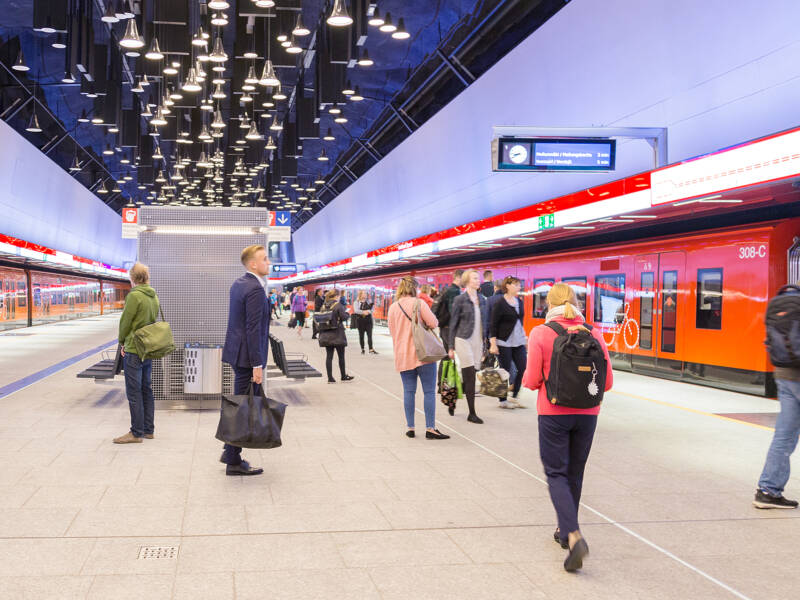 Ihmisiä ja kaksi metroa Espoon Keilaniemen metroasemalla.