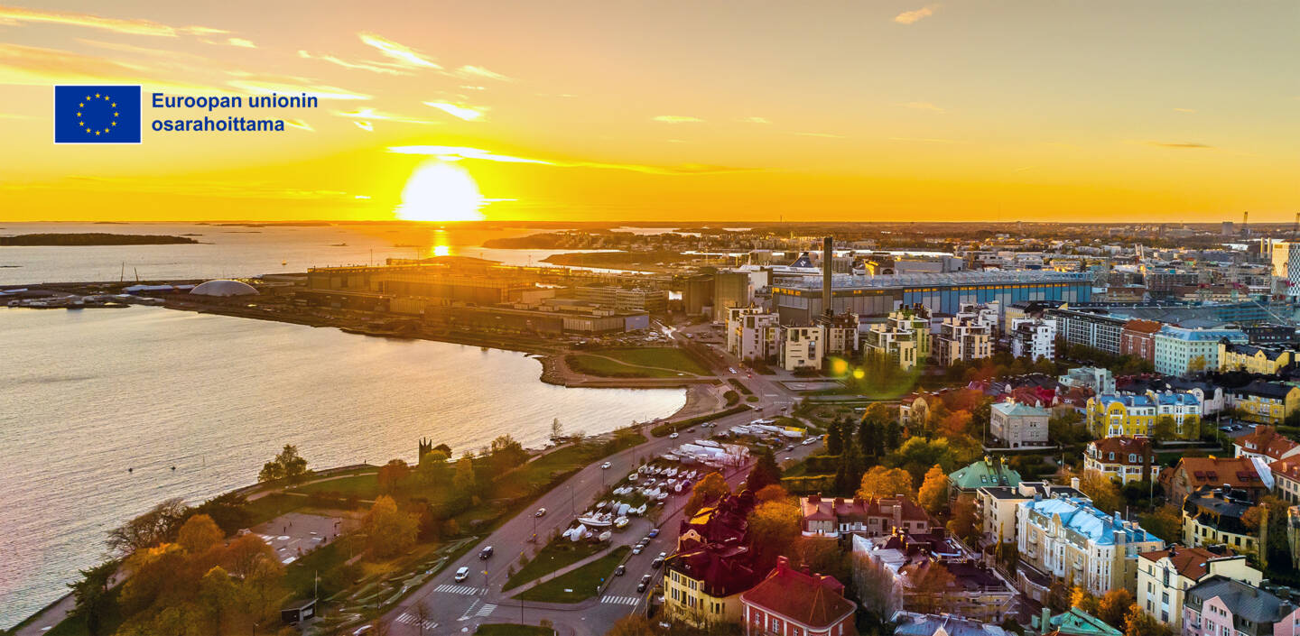 Kaupunkimaisemaa auringonlaskussa. EU-lippulogo, Euroopan unionin osarahoittama.